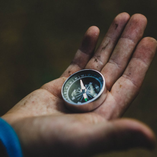 a hand holding a compass