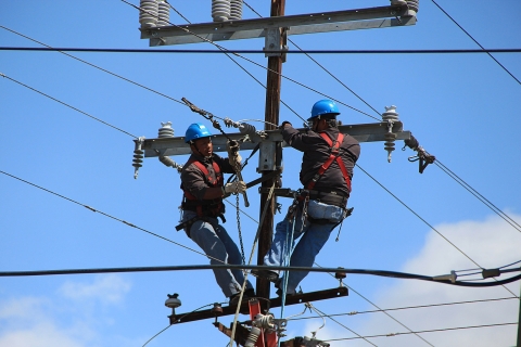 Image of men working on telephone pole