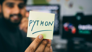 Image of man holding sticky note that says 'Python'